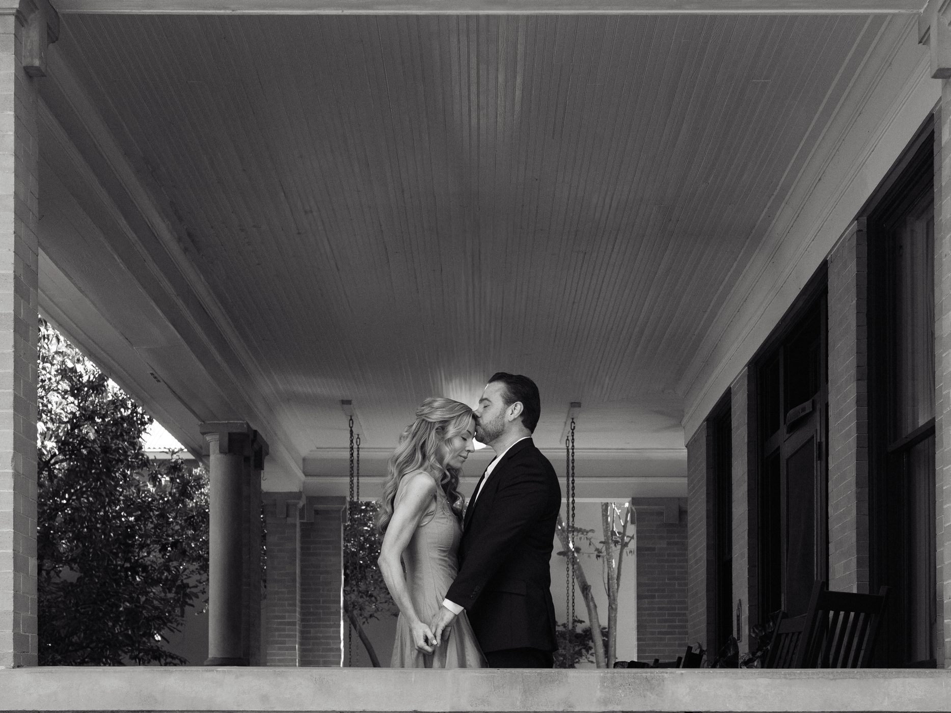 Chris and Brittney sharing a kiss under the porch