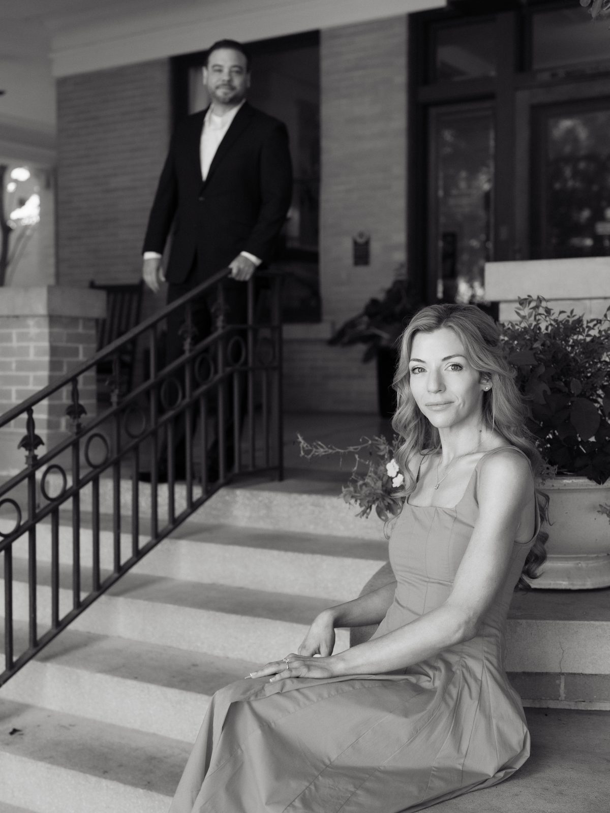 Brittney seated on the steps with Chris behind her