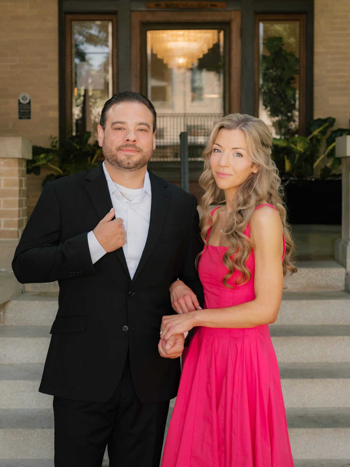 Chris and Brittney walking hand in hand up a garden path